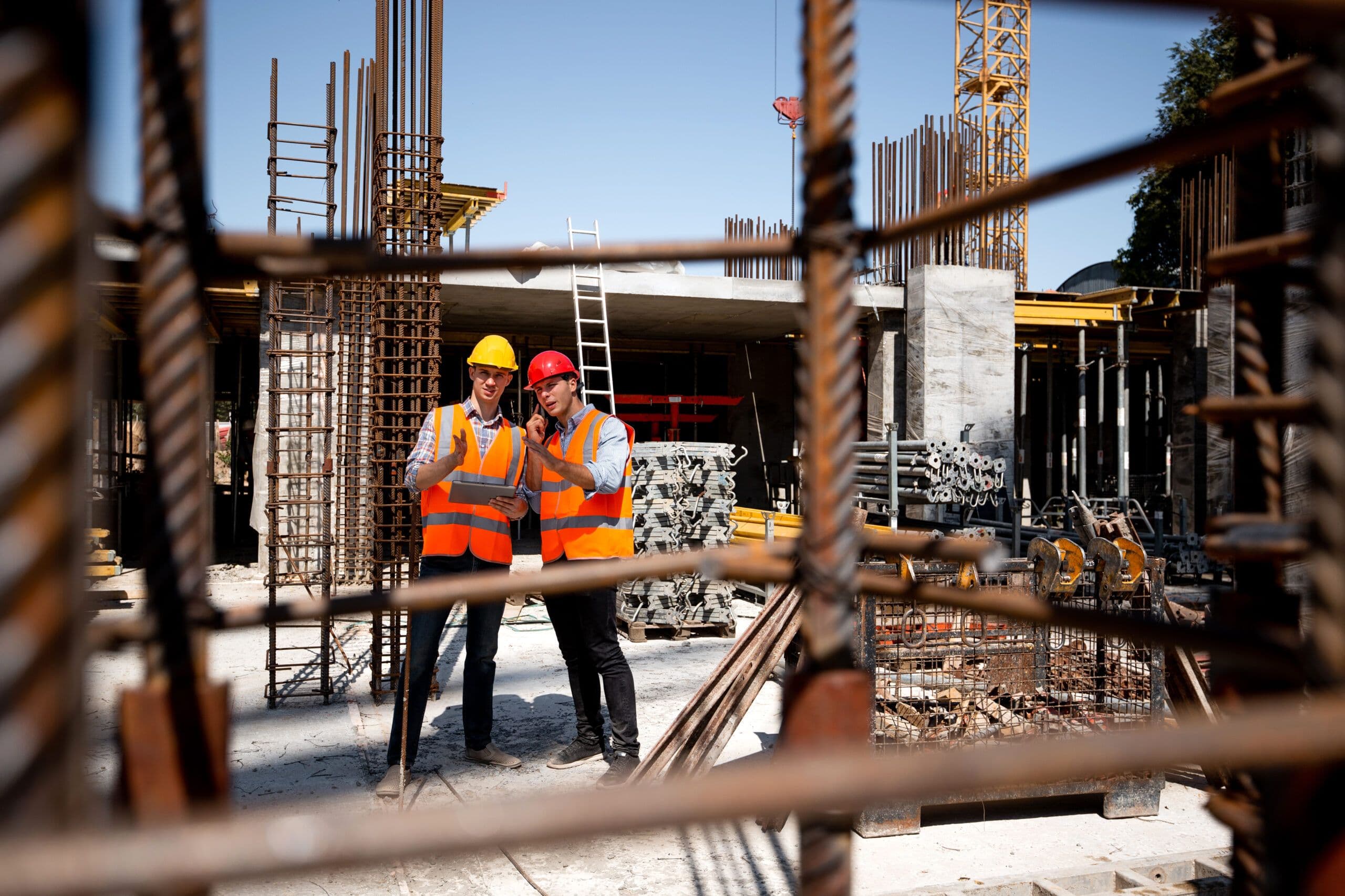 Ingenieros revisando una obra de construcción con una tableta